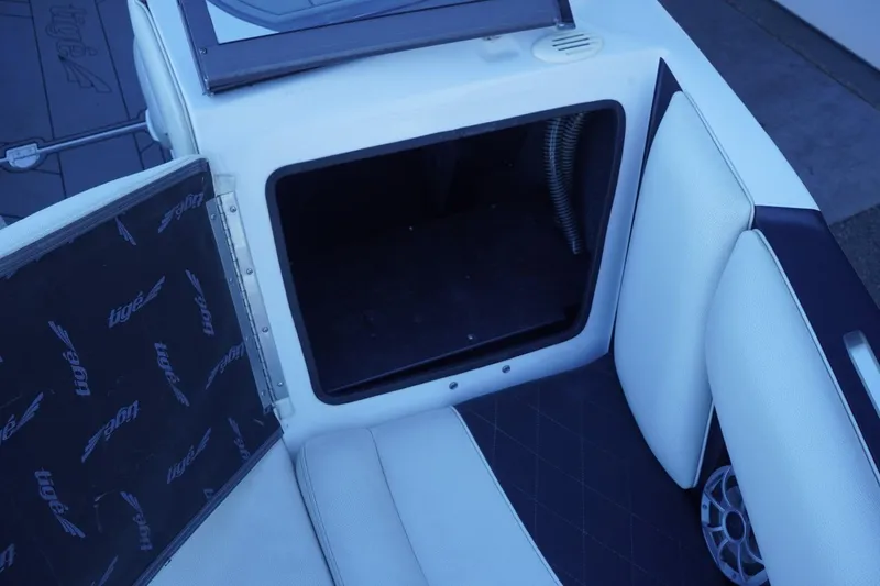 Slide: The Image of 2018 Tigé R22 boat interior storage compartment with white seating and speaker. - 30