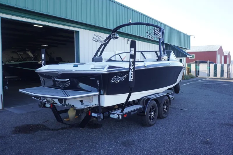 Slide: The Image of 2018 Tigé R22 boat on trailer outside a green warehouse. - 9