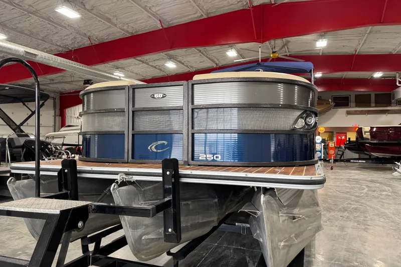 Slide: The Image of 2017 Crest III 250 pontoon boat in showroom, featuring sleek design and modern amenities. - 5