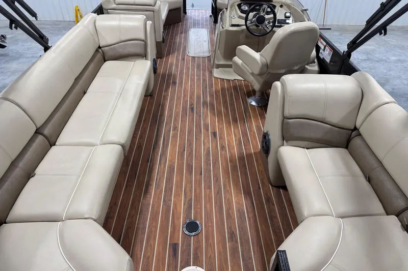 Slide: The Image of 2017 Crest III 250 pontoon boat interior with beige seating and wood-style flooring. - 6