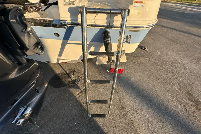 Slide: The Image of 2023 Robalo R222 Center Console boat with extended ladder on pavement. - 16