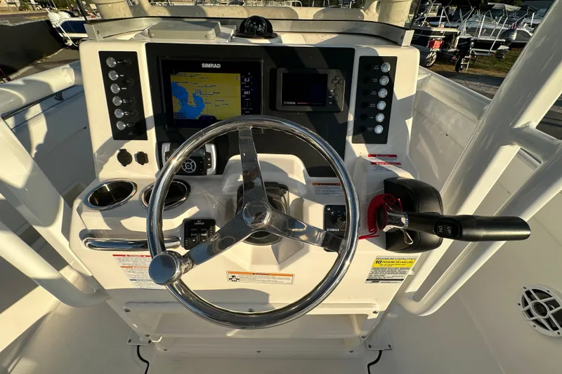 Slide: The Image of 2023 Robalo R222 Center Console boat dashboard with steering wheel and navigation system. - 25