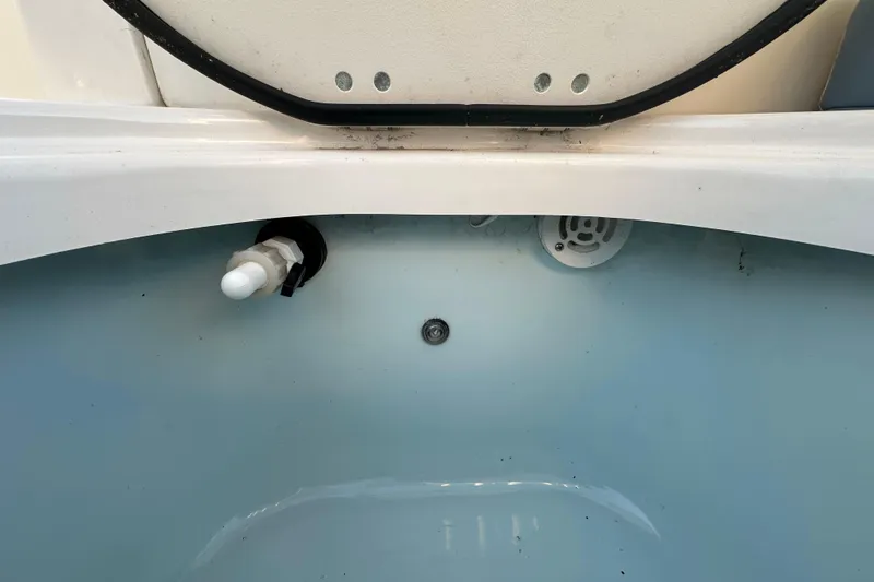 Slide: The Image of 2023 Robalo R222 Center Console livewell with open lid, showcasing interior features. - 61