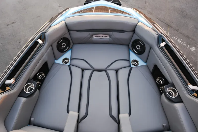 Slide: The Image of 2024 Supra SL boat interior with gray seating, cup holders, and speakers. - 14