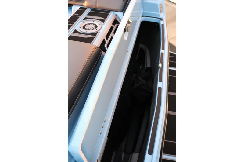 Slide: The Image of 2024 Supra SL boat interior storage compartment with sleek design and black seating. - 28