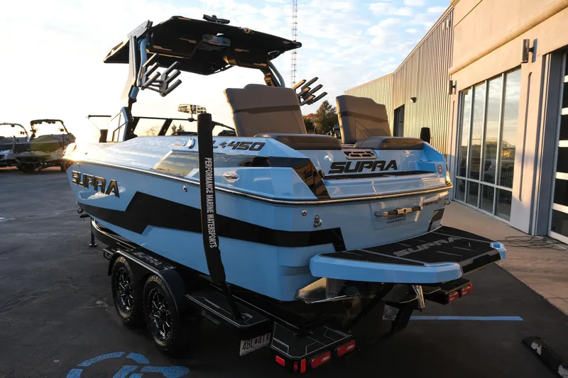 Slide: The Image of 2024 Supra SL boat in blue, parked outside a showroom. - 3
