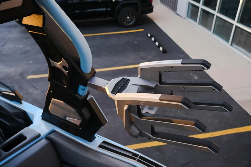 Slide: The Image of 2024 Supra SL boat with advanced wakeboard rack in a parking lot. - 32