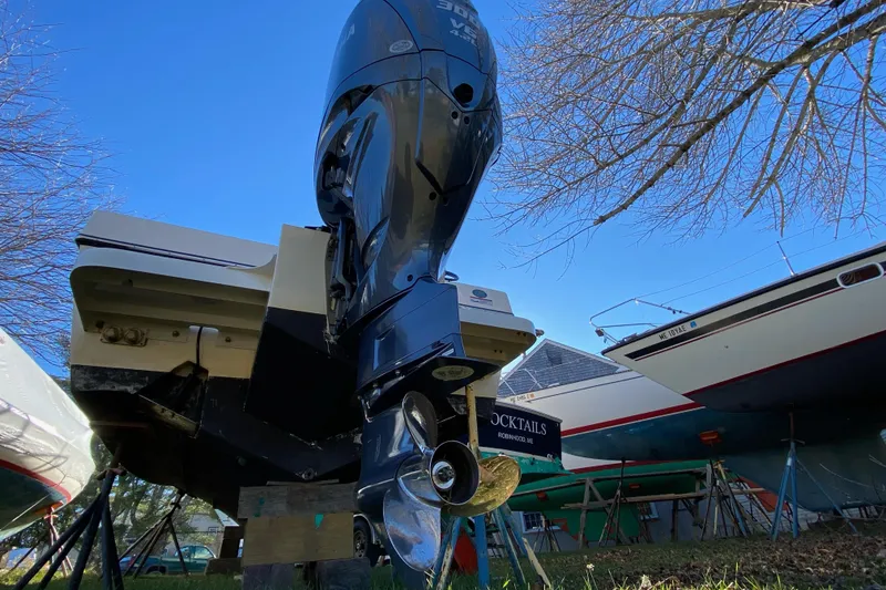 Slide: The Image of 2023 Defiance Admiral 250 EX boat with powerful outboard motor, docked outdoors. - 10