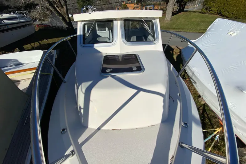 Slide: The Image of 2023 Defiance Admiral 250 EX boat deck with railing and cabin view. - 11