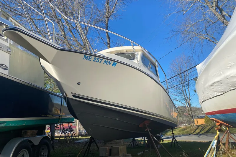 Slide: The Image of 2023 Defiance Admiral 250 EX boat on stands, clear blue sky background. - 12