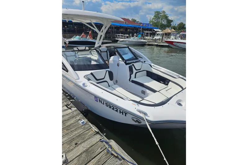 Slide: The Image of 2024 Yamaha Boats 275SD docked, showcasing sleek design and spacious seating. - 12