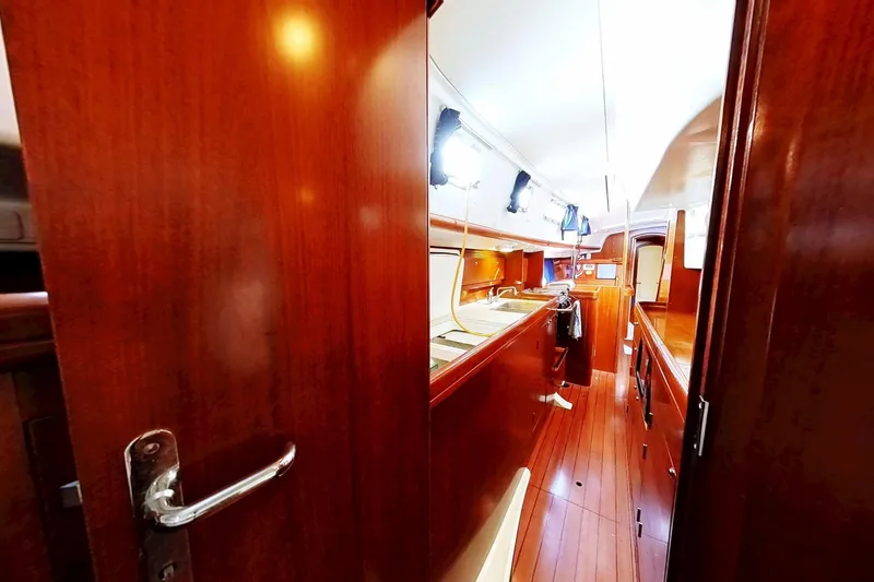 Slide: The Image of Interior view of 2003 Beneteau Oceanis 42CC sailboat, featuring wooden cabinetry and flooring. - 11