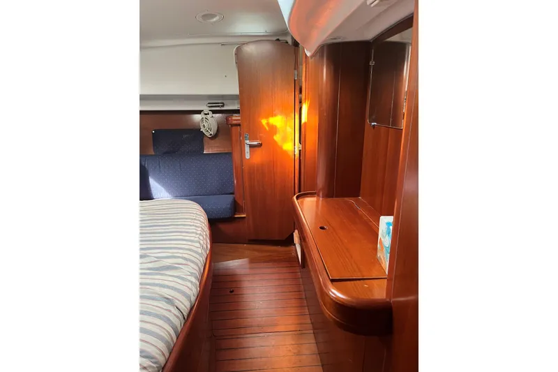 Slide: The Image of Interior of 2003 Beneteau Oceanis 42CC yacht with wooden furnishings and cozy seating area. - 16