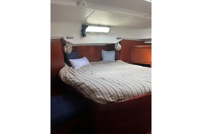 Slide: The Image of Cozy cabin interior of 2003 Beneteau Oceanis 42CC sailboat with striped bedding. - 19