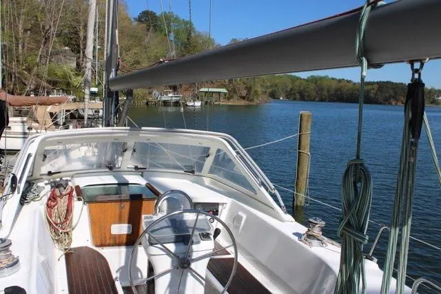 Slide: The Image of Cockpit view of 2003 Beneteau Oceanis 42CC sailboat docked by a serene lake. - 2