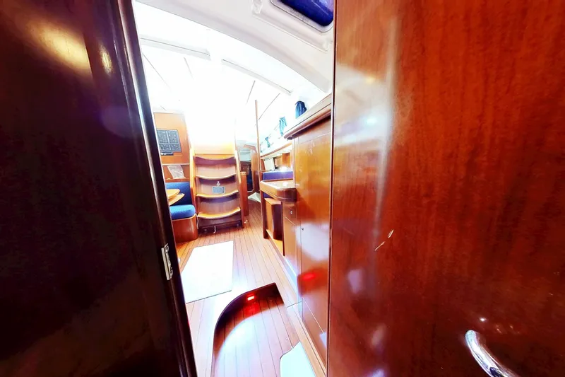 Slide: The Image of Interior view of 2003 Beneteau Oceanis 42CC sailboat with wooden finishes and seating area. - 28