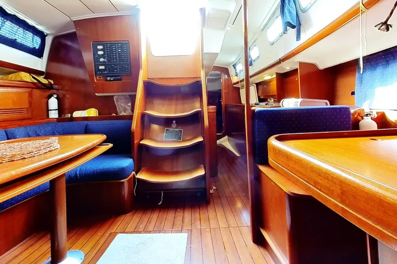 Slide: The Image of Interior of 2003 Beneteau Oceanis 42CC sailboat with wooden furnishings and blue seating. - 29