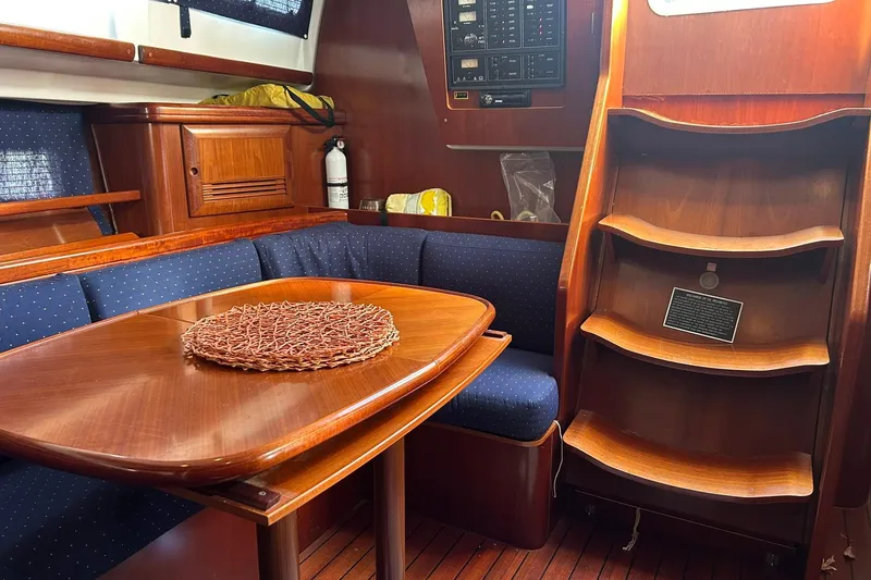 Slide: The Image of Interior of 2003 Beneteau Oceanis 42CC yacht with wooden table and blue seating. - 30