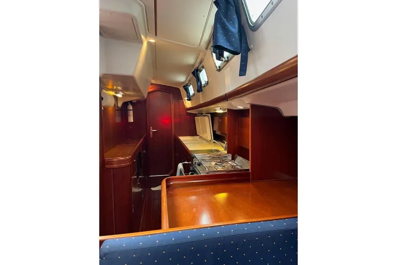 Slide: The Image of Interior of 2003 Beneteau Oceanis 42CC sailboat with wood finish and compact kitchen. - 36