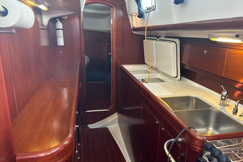 Slide: The Image of Interior of 2003 Beneteau Oceanis 42CC yacht with wooden cabinetry and kitchen sink. - 37