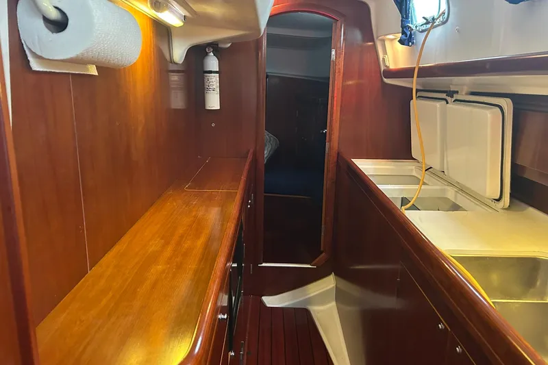 Slide: The Image of Interior of 2003 Beneteau Oceanis 42CC yacht with wooden cabinetry and kitchen area. - 39