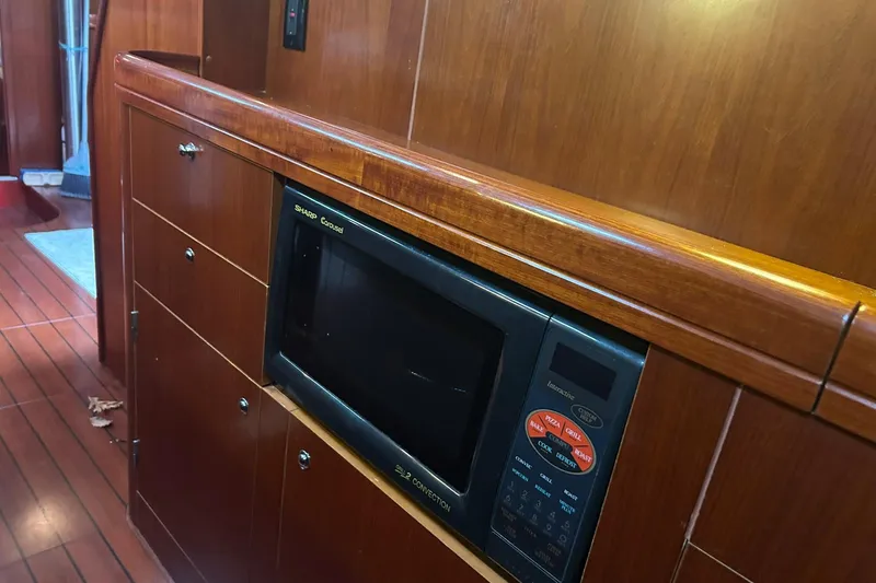 Slide: The Image of Wooden interior of 2003 Beneteau Oceanis 42CC yacht with built-in microwave. - 41