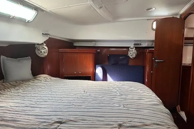 Slide: The Image of Cozy cabin interior of 2003 Beneteau Oceanis 42CC sailboat with striped bedding. - 44