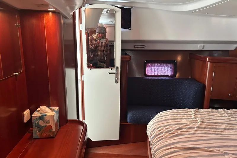 Slide: The Image of Interior of 2003 Beneteau Oceanis 42CC yacht with wood finish and cozy seating area. - 48