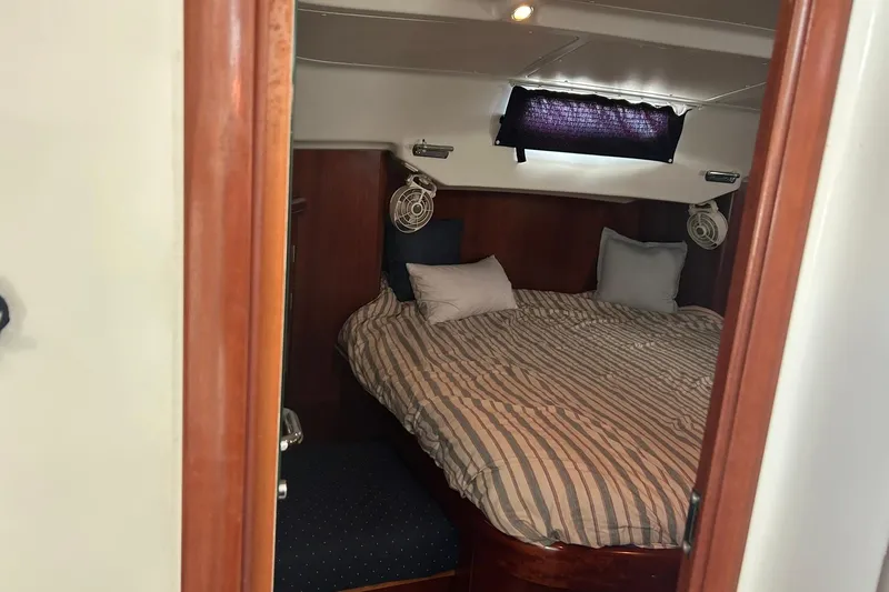 Slide: The Image of Cozy cabin interior of 2003 Beneteau Oceanis 42CC sailboat with striped bedding. - 56