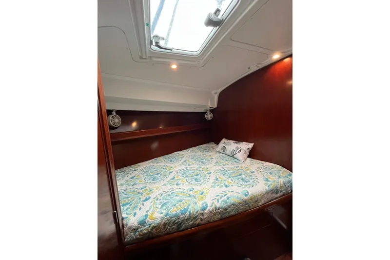 Slide: The Image of Cozy cabin interior of 2003 Beneteau Oceanis 42CC with patterned bedding and wood finish. - 58