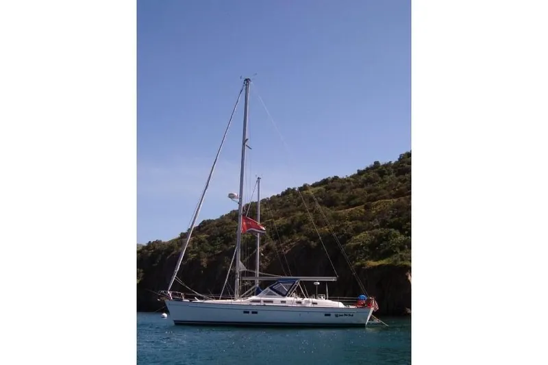 Slide: The Image of 2003 Beneteau Oceanis 42CC sailboat anchored near a scenic coastline. - 63