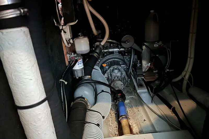 Slide: The Image of Engine room of 2003 Beneteau Oceanis 42CC sailboat, showcasing mechanical components and hoses. - 68