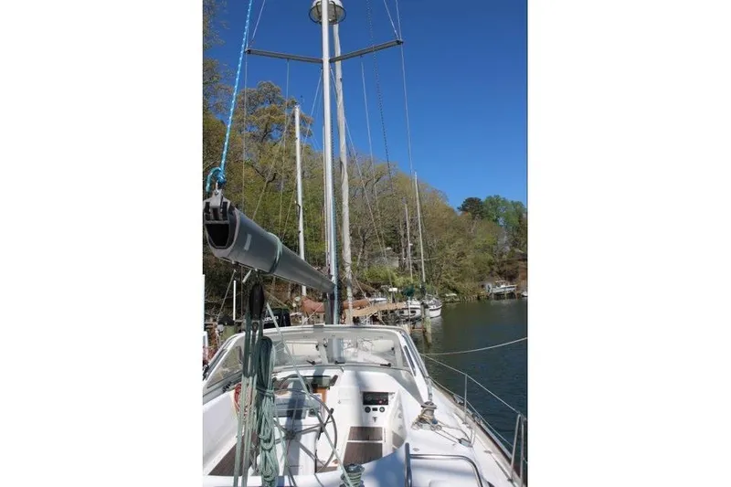 Slide: The Image of 2003 Beneteau Oceanis 42CC sailboat docked, featuring mast and rigging against clear blue sky. - 75