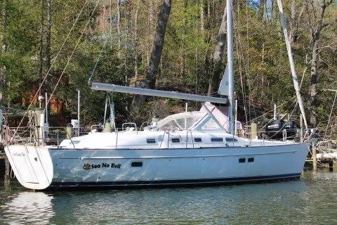 Slide: The Image of 2003 Beneteau Oceanis 42CC sailboat docked in a serene wooded marina. - 76