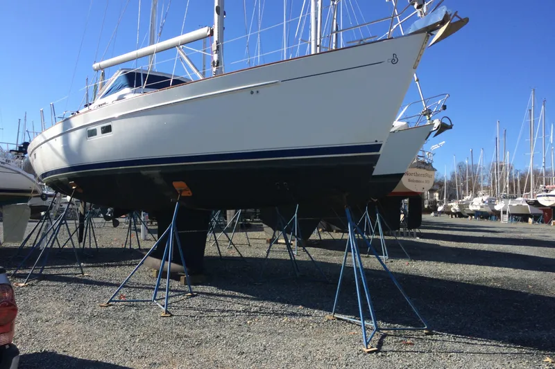 Slide: The Image of 2003 Beneteau Oceanis 42CC sailboat on stands in a boatyard under clear blue sky. - 78