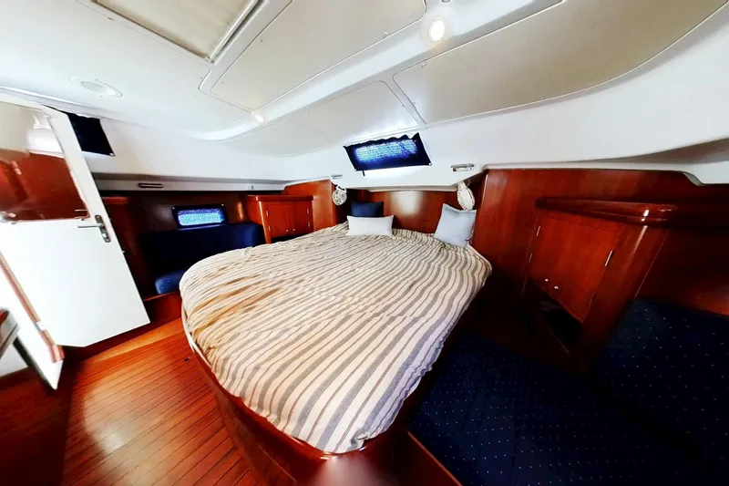 Slide: The Image of Luxurious cabin interior of 2003 Beneteau Oceanis 42CC yacht with cozy bed and wood finish. - 8