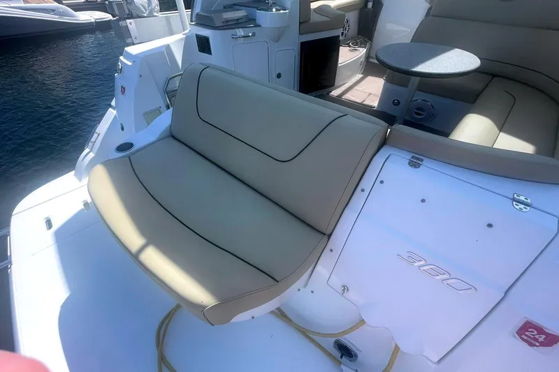 Slide: The Image of 2014 Cruisers Yachts 380 Express interior with beige seating and table, docked by the water. - 7