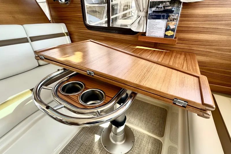 Slide: The Image of Interior of 2026 Ranger Tugs R-31 CB with wooden table and cup holders. - 12