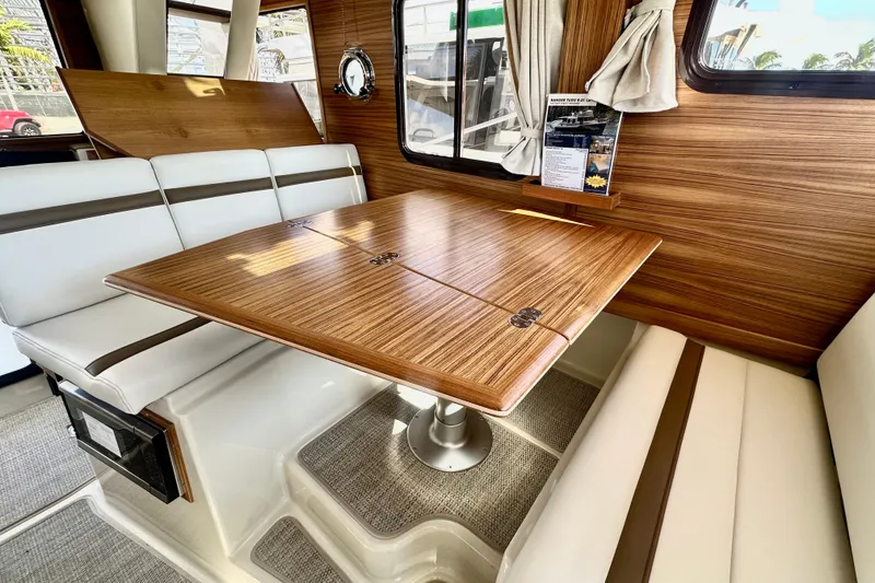 Slide: The Image of Interior of 2026 Ranger Tugs R-31 CB with wood table and white seating. - 13
