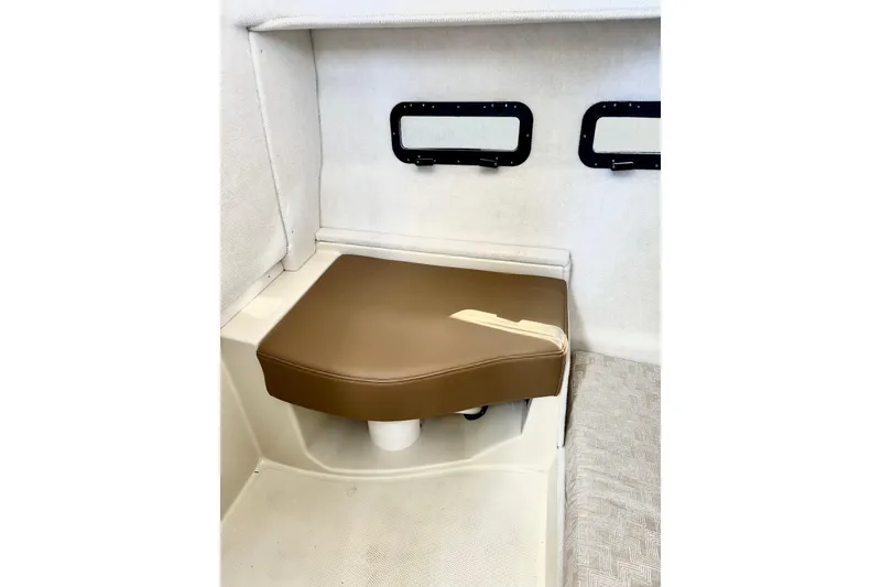Slide: The Image of Interior seating of 2026 Ranger Tugs R-31 CB boat, featuring brown cushion and windows. - 16
