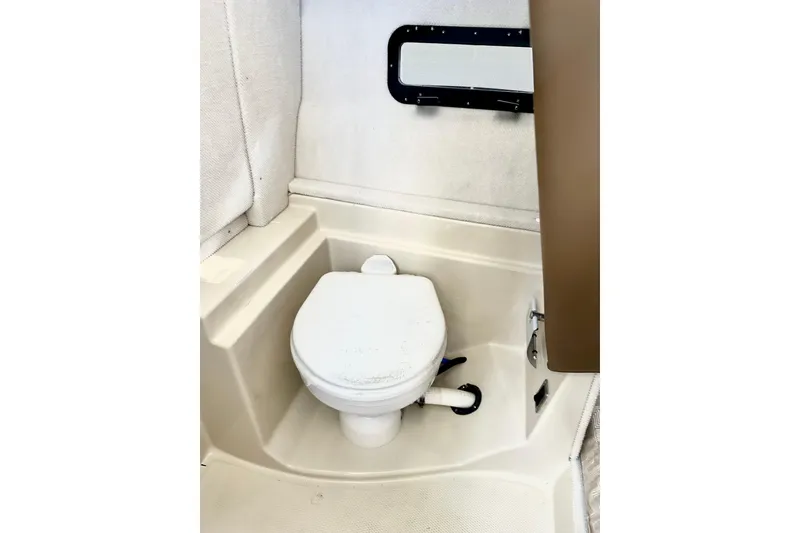 Slide: The Image of 2026 Ranger Tugs R-31 CB boat bathroom interior with compact toilet and window. - 17