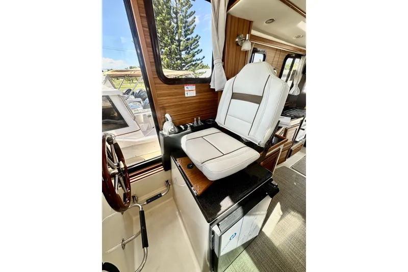 Slide: The Image of Captain's seat in 2026 Ranger Tugs R-31 CB boat interior, featuring wood accents and modern design. - 19