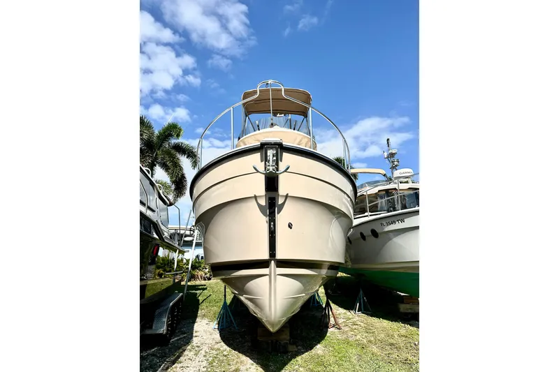 Slide: The Image of 2026 Ranger Tugs R-31 CB boat on land under a clear blue sky. - 2