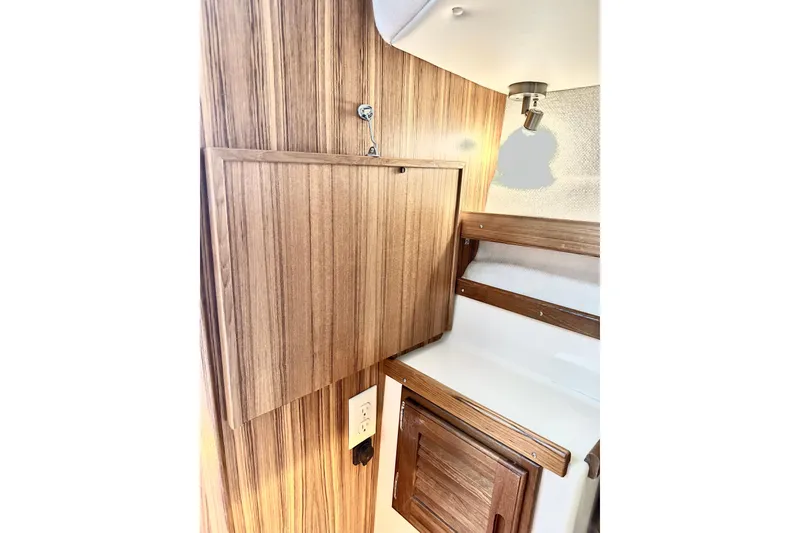 Slide: The Image of Interior of 2026 Ranger Tugs R-31 CB, featuring wood paneling and cabinetry. - 29