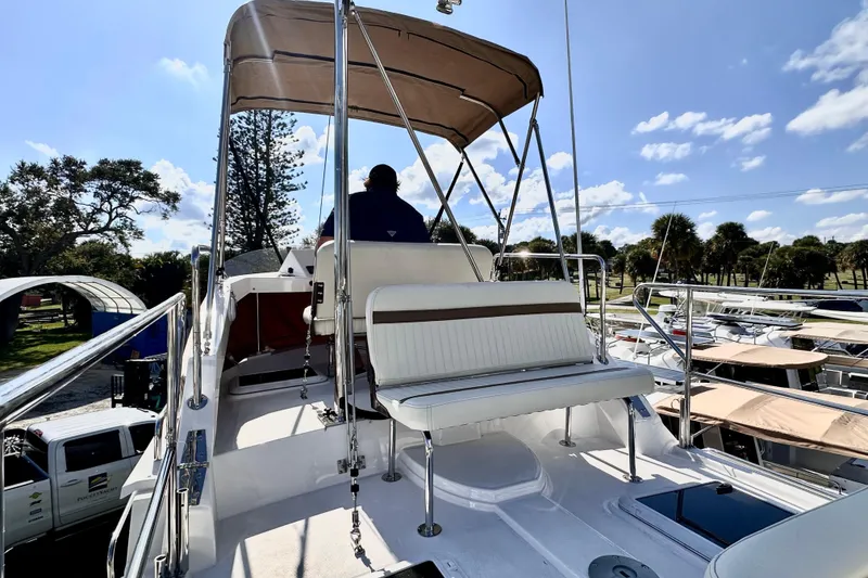Slide: The Image of 2026 Ranger Tugs R-31 CB boat with upper deck seating and canopy, docked under a sunny sky. - 38