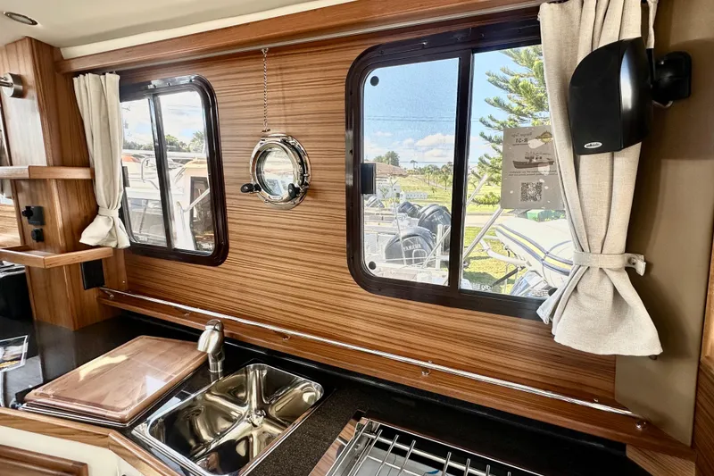 Slide: The Image of Interior of 2026 Ranger Tugs R-31 CB, featuring a modern kitchen with wood accents. - 5