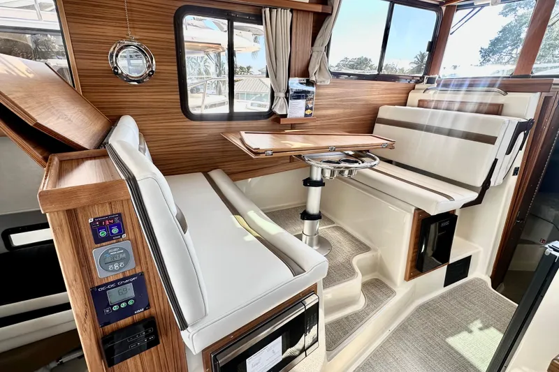 Slide: The Image of Interior of 2026 Ranger Tugs R-31 CB, featuring elegant seating and wood accents. - 8