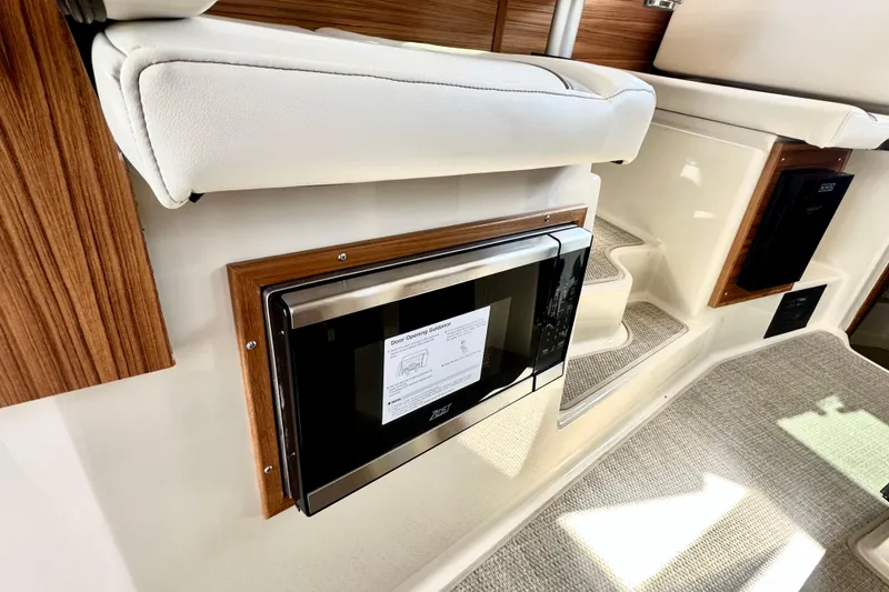 Slide: The Image of Interior of 2026 Ranger Tugs R-31 CB, featuring a built-in microwave and stylish wood accents. - 9