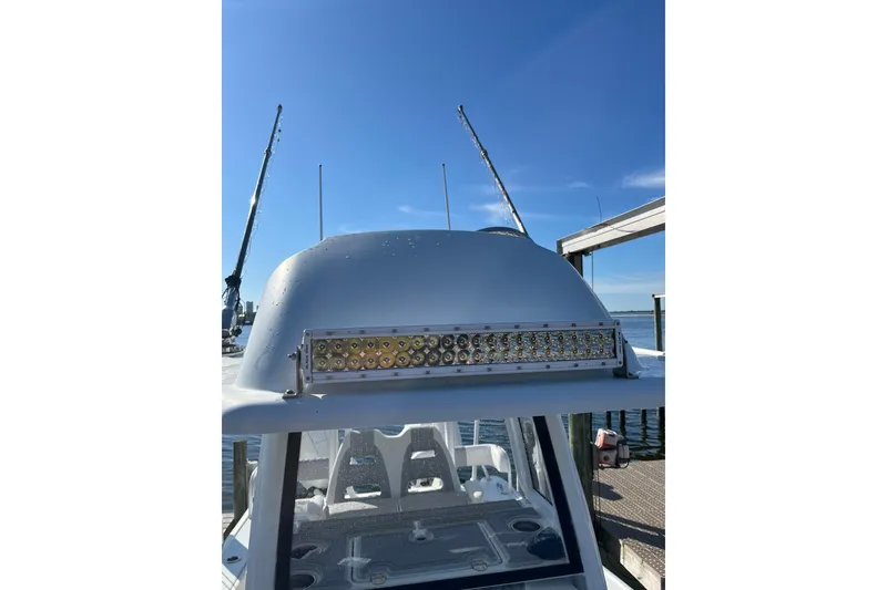 Slide: The Image of 2022 Costa Custom Boats 264 with LED light bar, docked under clear blue sky. - 11