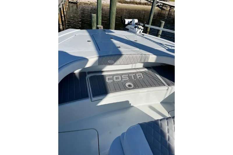 Slide: The Image of 2022 Costa Custom Boats 264 deck with logo, featuring sleek design and comfortable seating. - 12